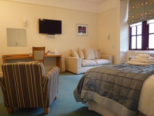 a hotel room with a bed and a couch at Pentland Lodge House in Thurso