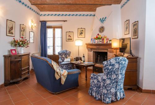 a living room with two chairs and a fireplace at Ormanni nel Chianti Classico in Barberino di Val dʼElsa