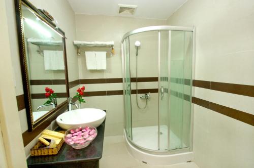 a bathroom with a shower and a toilet and a sink at Luxury Nha Trang Hotel in Nha Trang