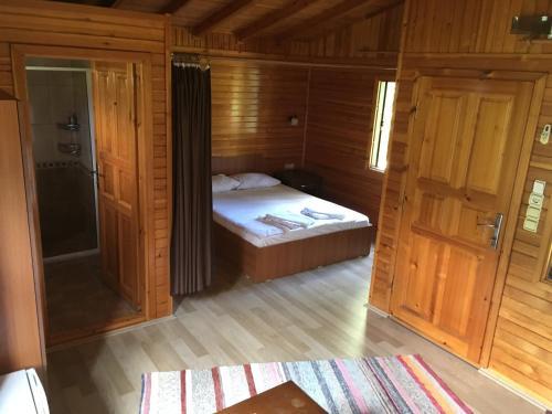 Un dormitorio pequeño con una cama y una ducha. en Ozge Bungalow Hotel, en Cıralı