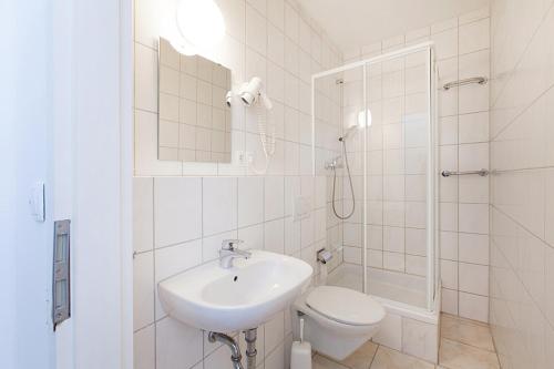 a bathroom with a sink and a toilet and a shower at Pension Jasmin in Pforzheim