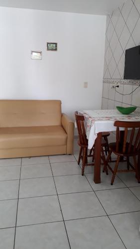 a room with a table and a couch and a table and chairs at Pousada Mar Verde in Florianópolis