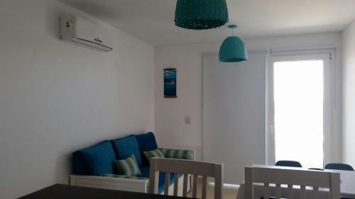 ein Wohnzimmer mit einem Tisch und einem blauen Sofa in der Unterkunft Mareas del Golfo in Las Grutas