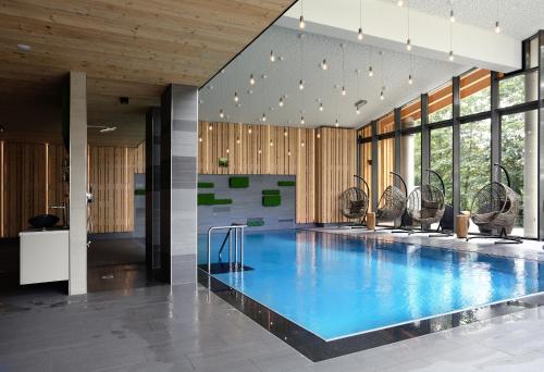a swimming pool in a building with a gym at Konsum Berghotel Oberhof in Oberhof