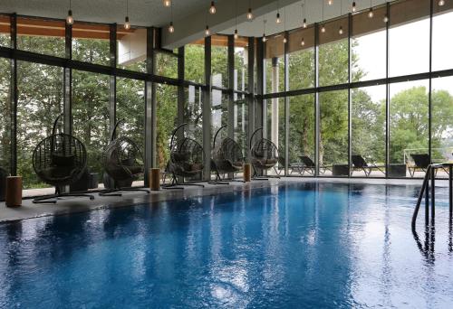 a large swimming pool with chairs and windows at Konsum Berghotel Oberhof in Oberhof