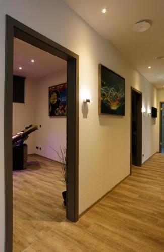 a hallway with a room with a piano and paintings at Konsum Berghotel Oberhof in Oberhof