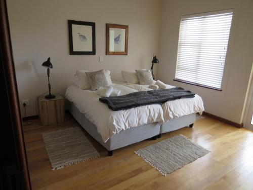 um quarto com uma cama com lençóis brancos e almofadas em Spoil Yourself em Swakopmund