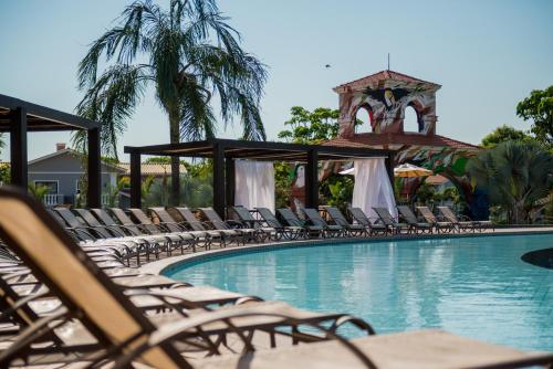 a swimming pool with lounge chairs and a gazebo at Wish Foz do Iguaçu in Foz do Iguaçu