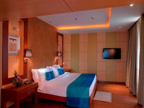 Un pat sau paturi într-o cameră la Royal Orchid Central Kireeti-HAMPI Hospet