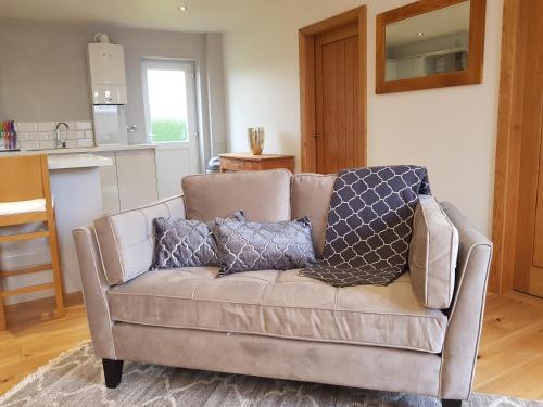 a couch with three pillows on it in a living room at The Studio in Ingoldmells