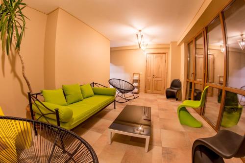 a living room with a green couch and chairs at Hotel Deka in Gudauri