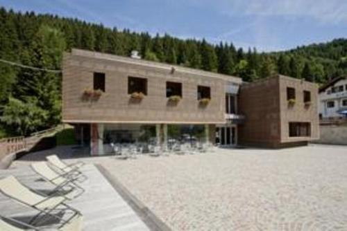 un gran edificio con sillas delante en Hotel Kube, en Folgaria
