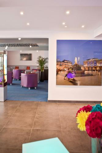a lobby with purple chairs and a large picture on the wall at Privilège Hôtel & Apparts Eurociel Centre Comédie in Montpellier