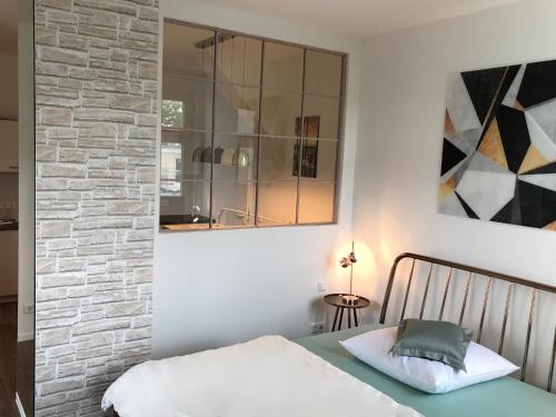 a bedroom with a bed and a brick wall at Quartier 1903 in Oldenburg