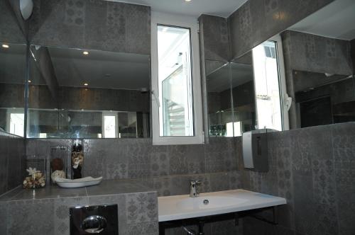 a bathroom with a sink and a mirror at Privilège Hôtel & Apparts Eurociel Centre Comédie in Montpellier