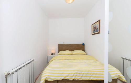 a bedroom with a bed with a yellow and white striped blanket at Apartman Mira in Daruvar