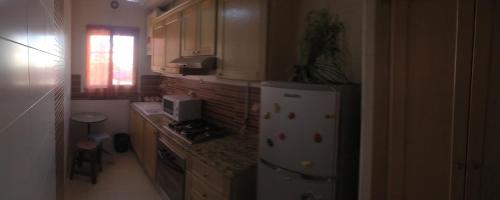 eine Küche mit einem weißen Kühlschrank und einer Arbeitsplatte in der Unterkunft Résidence Tasnim in Ariana