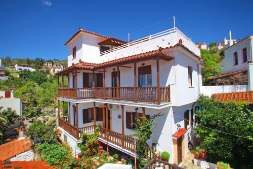 a white house with balconies on a hill at Kamara House in Skopelos Town