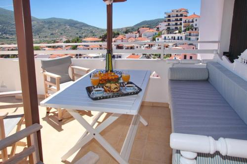 a table with a tray of food on a balcony at Kamara House in Skopelos Town