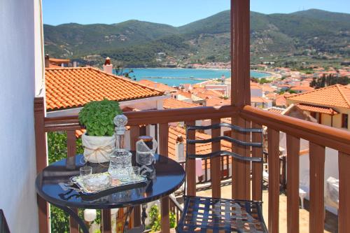 a table on a balcony with a view of a city at Kamara House in Skopelos Town