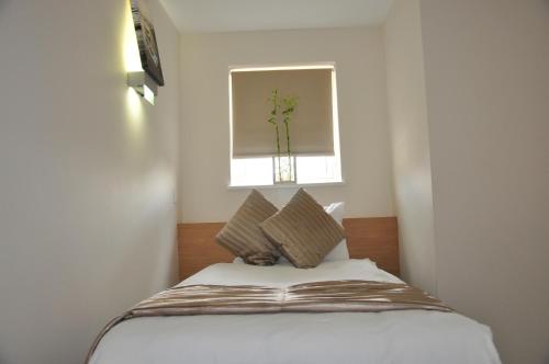 a bed in a room with a window at Queens Hotel in London