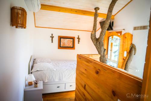 a bedroom with a bed and a mirror in a room at Cabane Dans les Arbres, Domaine de l Ogliastru in Olmeto
