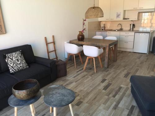 a living room with a couch and a table and chairs at appartementen zeespiegel in Zandvoort