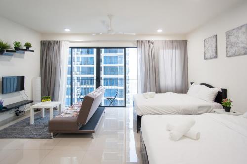 a white bedroom with two beds and a couch at Miko's Studio @ Setia Convention in Shah Alam