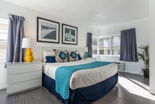 a bedroom with a blue and white bed and windows at Nobleton Hotel in Fort Lauderdale