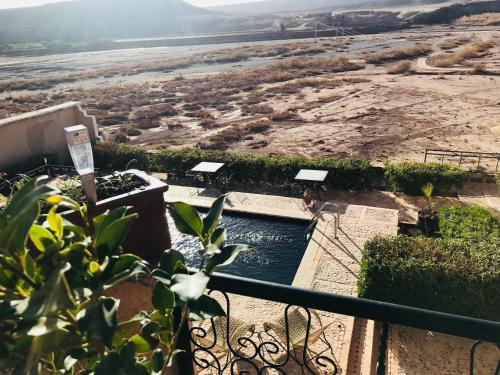 a pool of water with a view of a field at Kasbah Rayane Ait Ben Haddou in Aït Ben Haddou