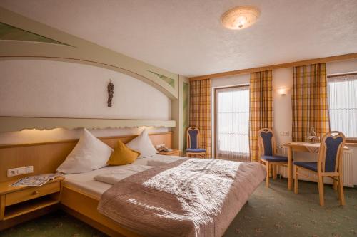 Habitación de hotel con cama, mesa y sillas en Walchenhof en Mayrhofen