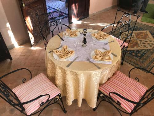 a table with a white table cloth and two chairs at Kasbah Rayane Ait Ben Haddou in Aït Ben Haddou