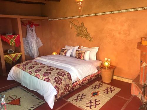 a bedroom with a bed with a white comforter at Kasbah Rayane Ait Ben Haddou in Aït Ben Haddou
