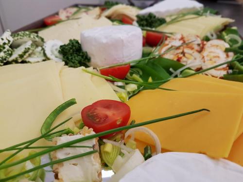 a plate of food with cheese and vegetables on it at Hotel Zur Luppbode in Treseburg