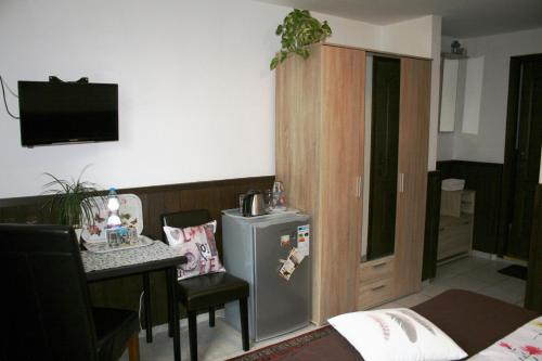 a kitchen with a small refrigerator and a table with chairs at Fontana Vendégház in Tát