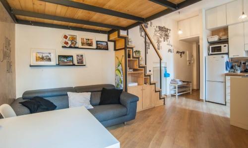ein Wohnzimmer mit einem blauen Sofa und einer Küche in der Unterkunft Terrace99 in Rom
