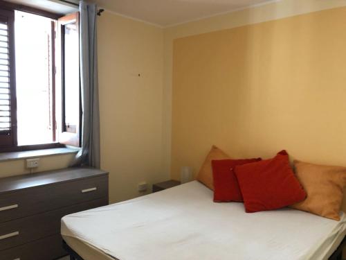 バゲリーアにあるBaarìa casa vacanzeのベッドルーム1室(赤い枕のベッド1台、窓付)