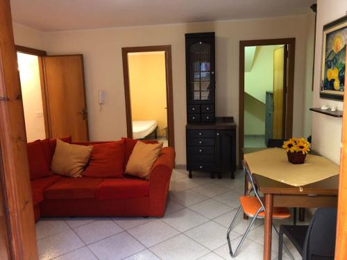 バゲリーアにあるBaarìa casa vacanzeのリビングルーム(赤いソファ、テーブル付)