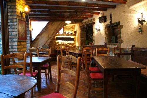 un restaurante con mesas y sillas de madera y chimenea en Casa Labata, en Adahuesca