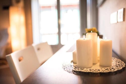 two white candles sitting on top of a table at Maison Di Gugli in Brandizzo