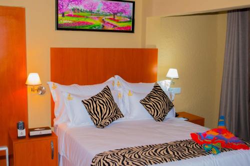 a hotel room with a bed with zebra pillows at Rekky Signature Guesthouse in Johannesburg