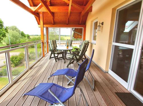 eine Veranda mit Stühlen und einem Tisch auf dem Balkon in der Unterkunft HAUS MÜRITZBRISE / OG-Fewo in Klink