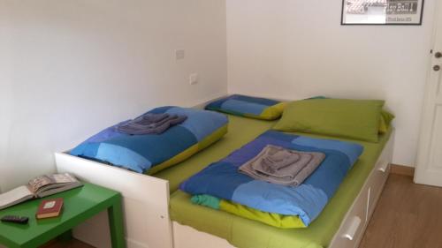 two twin beds in a room with a table at Bed&Breakfast Angela in Clusone