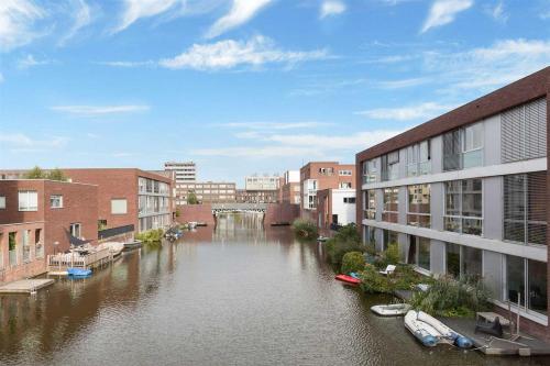 a river in a city with buildings and boats in it at The Water Studio in Amsterdam