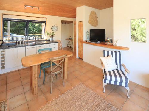 a kitchen with a wooden table and chairs in a room at La Maisonette in Onetangi