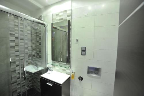 a white bathroom with a sink and a shower at Casa Di Lusso in Ioannina