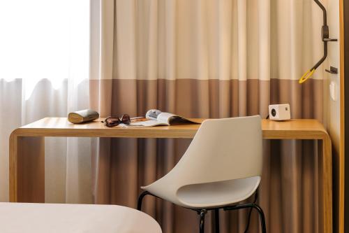 a desk with a chair and a lamp in front of it at ibis Hotel Berlin Mitte in Berlin