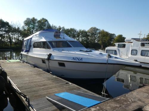 a white boat is docked at a dock at Domaine du Port Sainte Marie in Maizières-lès-Vic