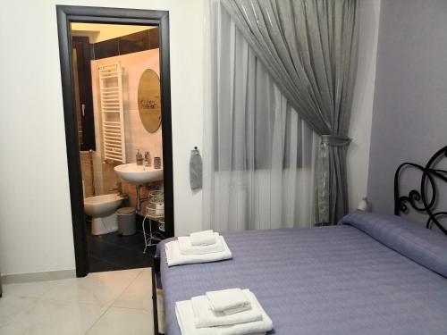 a bedroom with a bed and a bathroom with a sink at B&B LA CASA DI GIORGIA DI PELLICANO' FRANCESCA in Reggio di Calabria