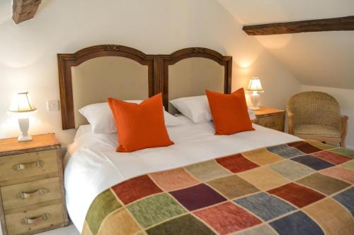 a bedroom with a large bed with orange pillows at Bang in Wells in Wells next the Sea